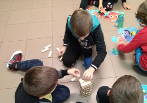 Chłopcy układają wieżę z klocków Jenga oraz obrazek z puzzli